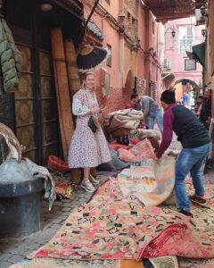 Cosa grunnlegger Hege i medinaen i Marrakech. Teppehandlere viser frem masse fargerike tepper i beige og rosatoner