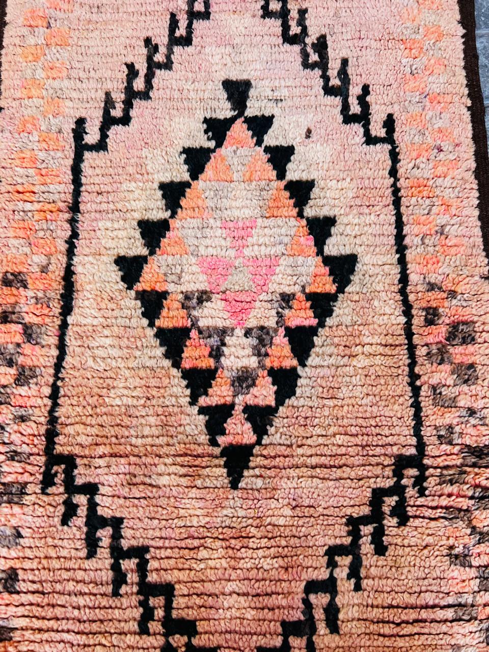 Et marokkansk vintageteppe i nydelig kombinasjon av gyldne rosa- og bruntoner. En løper som er håndknyttet av berberkvinner.