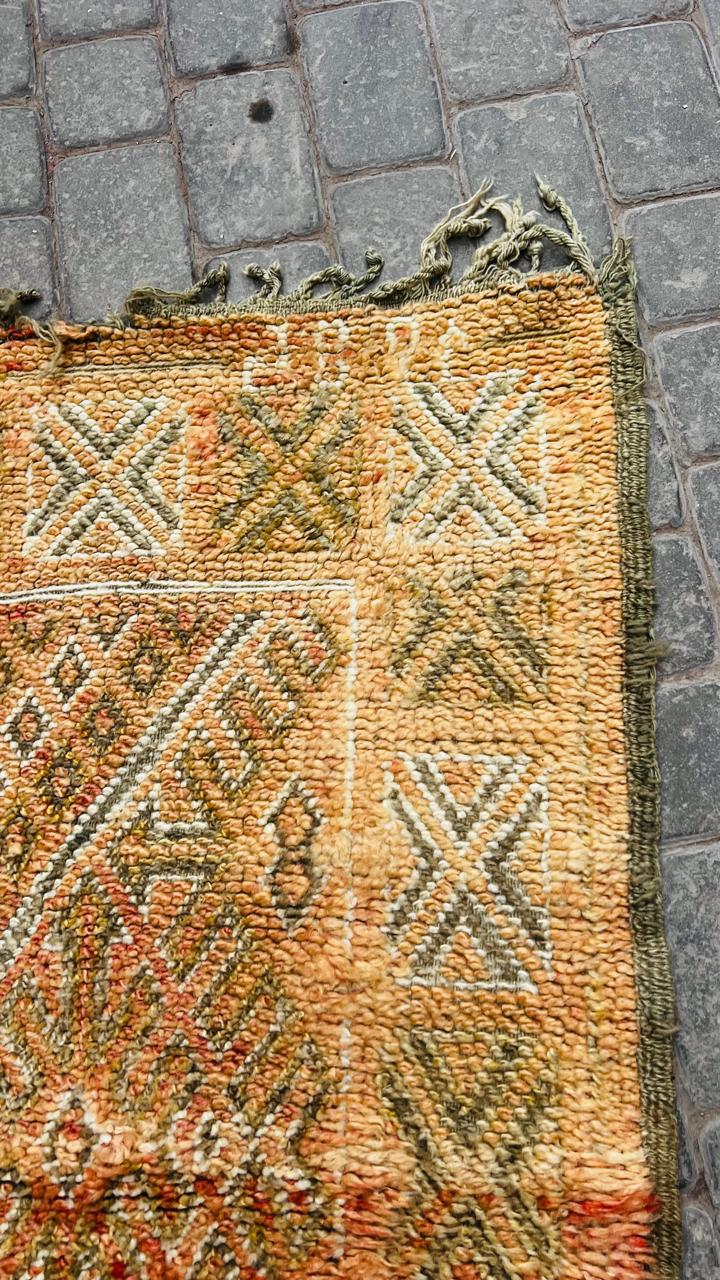 Vintage Beni Mguild berberteppe i gylne okertoner med geometrisk medaljongmønster.