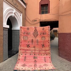 Vintage rosa marokkansk beojaad teppe. Diamant og stjerne mønstre som kjennetegner stammen. Teppet henger i en gate i Marrakech.