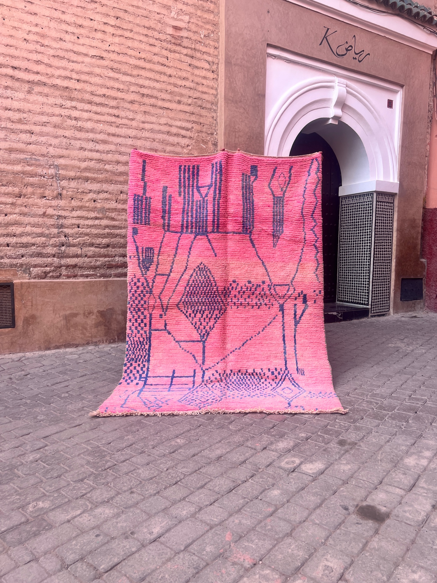 Et statement teppe I rosa og blå. Håndknyttet marokkansk berberteppe. Abstrakt mønster.